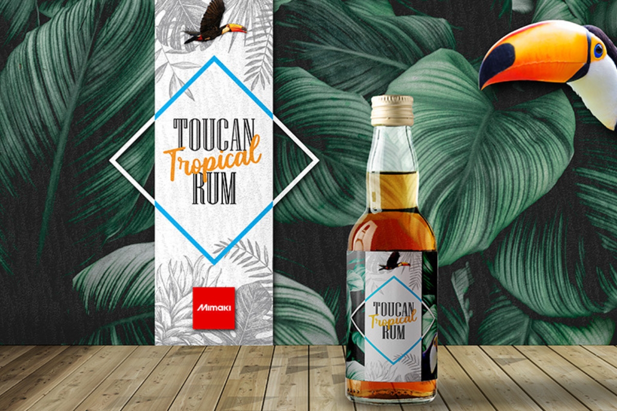 A bottle of rum featuring a digitally printed label sitting in front of a tropical wallpaper design, all produced with a Mimaki JV100-160