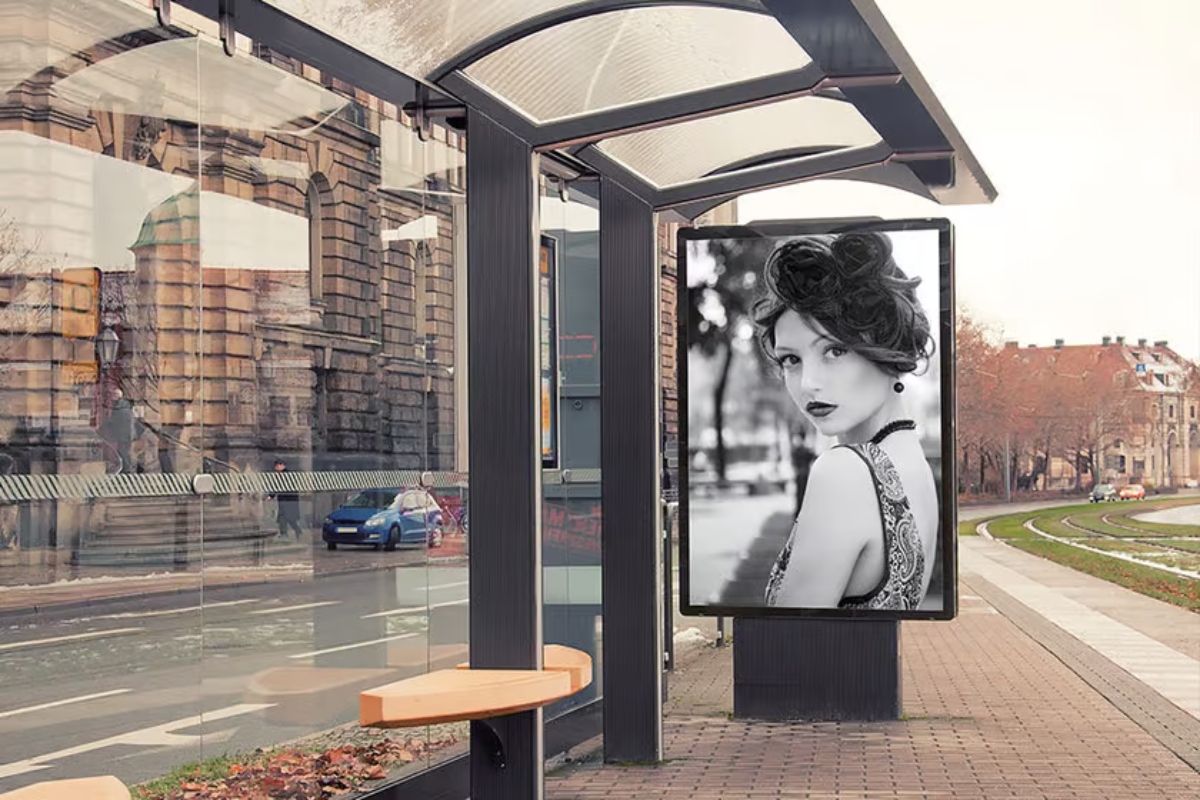 An urban bus shelter with a black and white advertisement