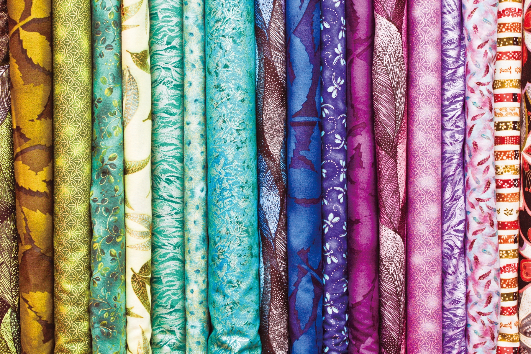 Rolls of brightly printed fabrics
