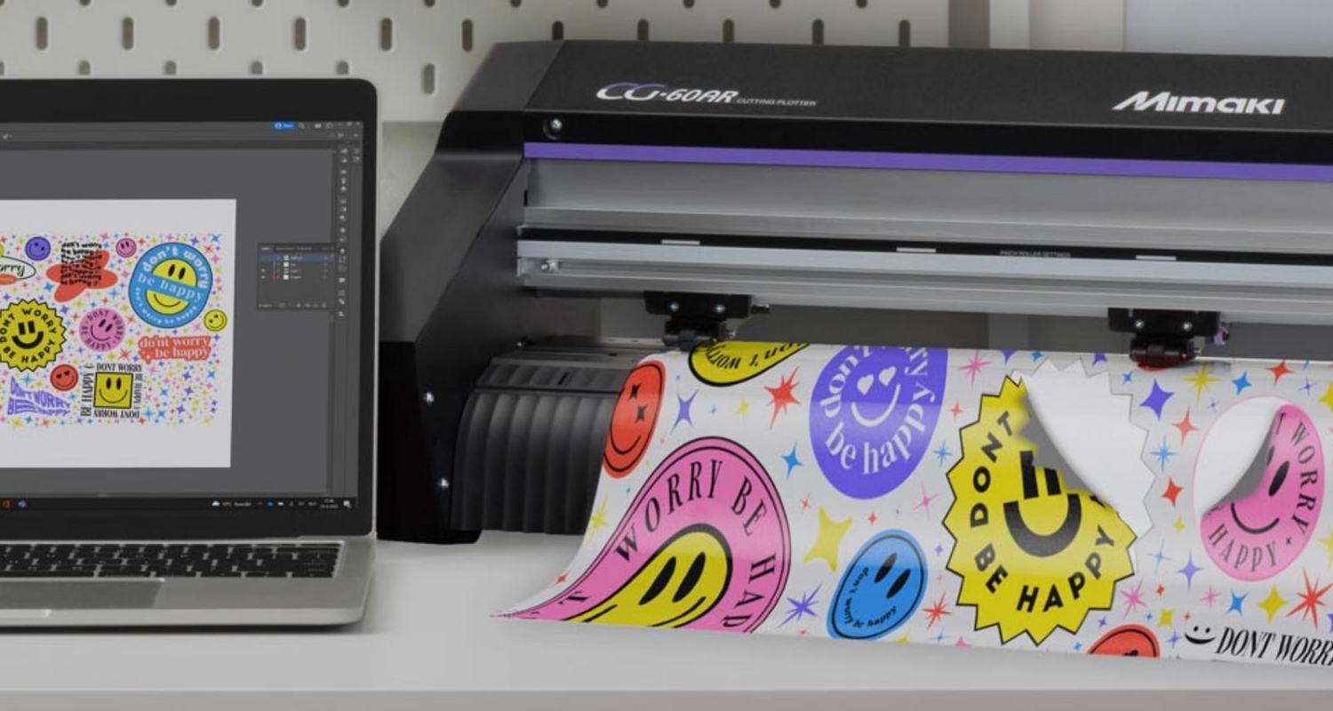 Mimaki CG-60AR 60cm vinyl cutter on a bench with some printed and cut stickers